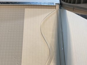 A paper slicer cutting lined notebook paper