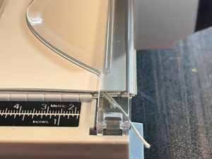 Trimming the edge of the mini journal with a paper slicer