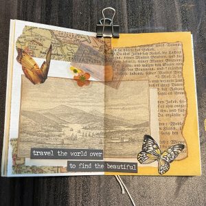 A finished mini junk journal spread with ephemera, washi tape, and stickers.