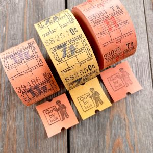 Three rolls of orange & yellow vintage British bus tickets