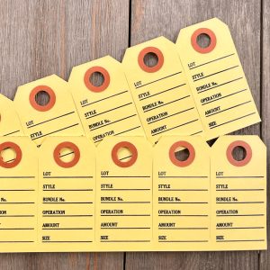 Two strips of six yellow vintage clothing tags