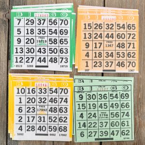 16 assorted vintage paper bingo sheets in green, yellow, and orange
