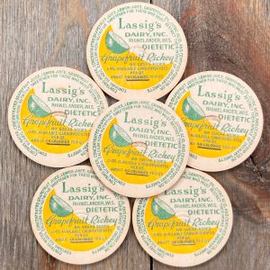 6 Vintage white, yellow, and green Lassig’s Dairy Grapefruit Rickey cardboard caps featuring an illustration of a lime