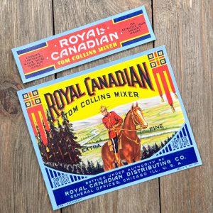 2 Different vintage Royal Canadian Tom Collins Mixer labels featuring a Canadian Mountie
