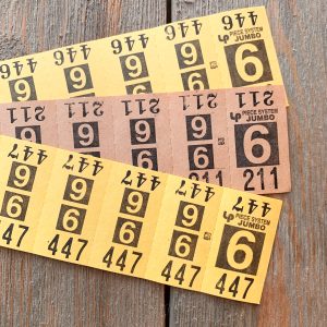 2 strips of yellow and 1 strip of beige vintage dry cleaning tickets