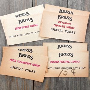 4 Piles of aged vintage Kress coupons for different types of ice cream sundaes - Peach, Chocolate, Strawberry and Pineapple