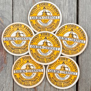 6 vintage yellow, black & white Golden Guernsey milk caps featuring an illustration of a jug of milk